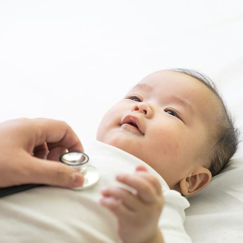 Baby having it's breathing checked with a stethoscope